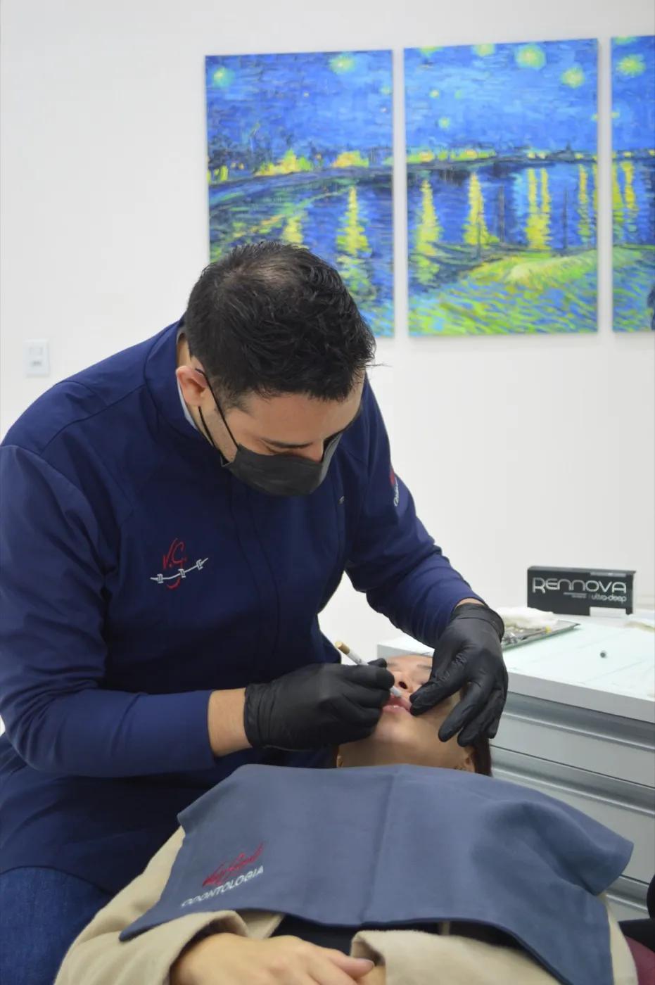 Cirurgião-dentista de máscara e luvas atendendo um paciente na clínica